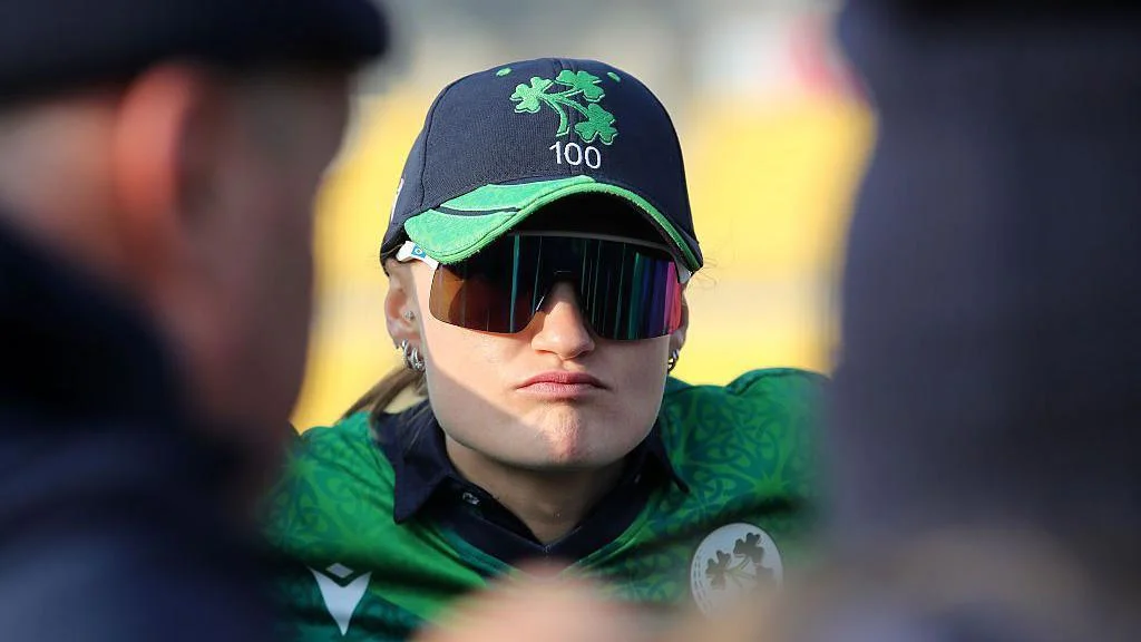 Close up of Gaby Lewis, pictured wearing sunglasses in a team huddle