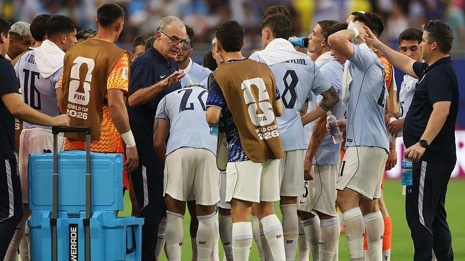 Uruguay's players listen to instructions from Marcelo Biesla during a hydration break