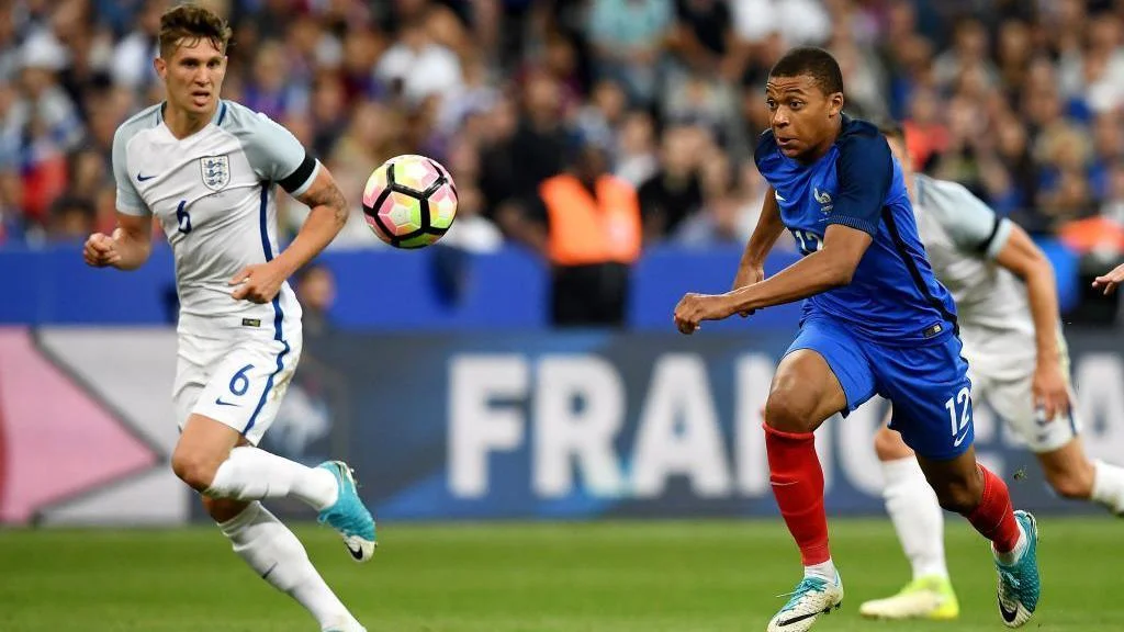 Kylian Mbappe accelerates past England's John Stones during a friendly in 2017