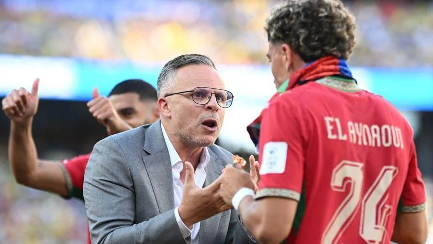 Morocco head coach Mohamed Ouahbi talks to Neil El Aynaoui during a hydration break against Brazil
