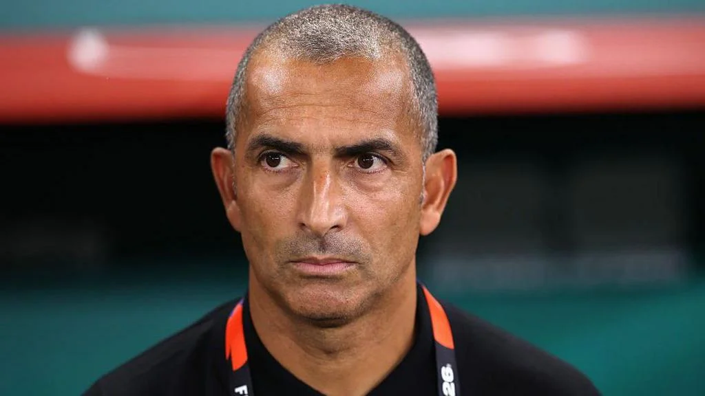 Close up of Sabri Lamouchi standing in the dugout looking focused