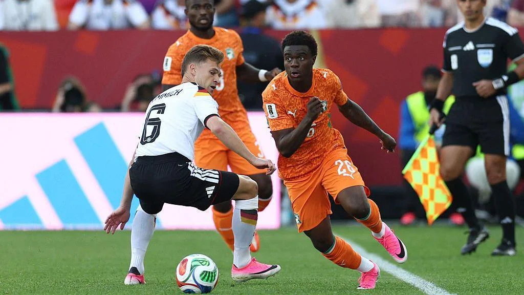 Ivory Coast's Christ Inao Oulai (right) beats Germany's Joshua Kimmich