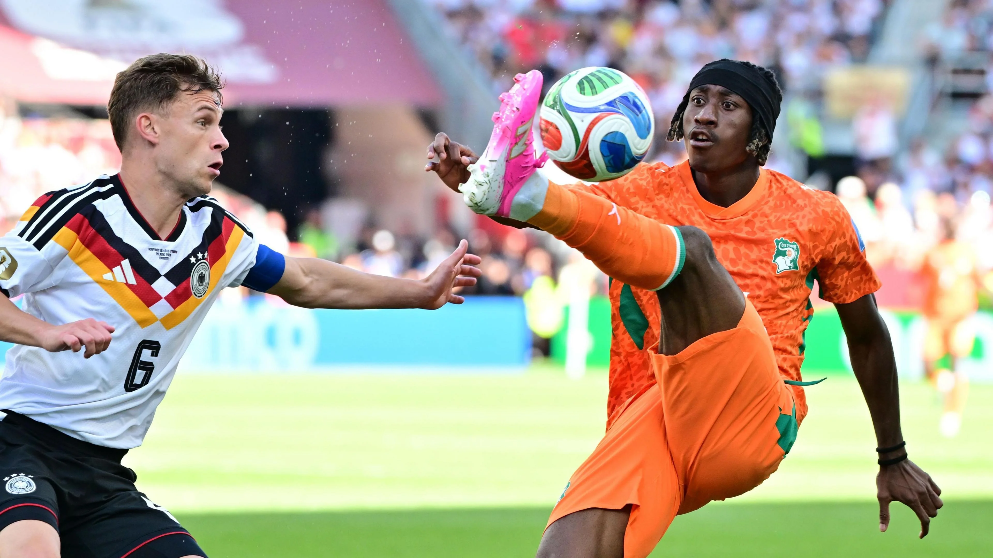 Yan Diomande (right) is challenged by Joshua Kimmich of Germany