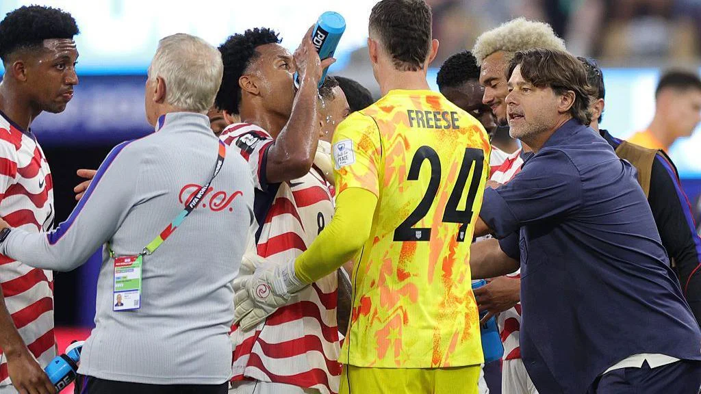 USA players drink near the touchline and listen to instructions from manager Mauricio Pochettino during the hydration break in their opening World Cup 2026 match against Paraguay